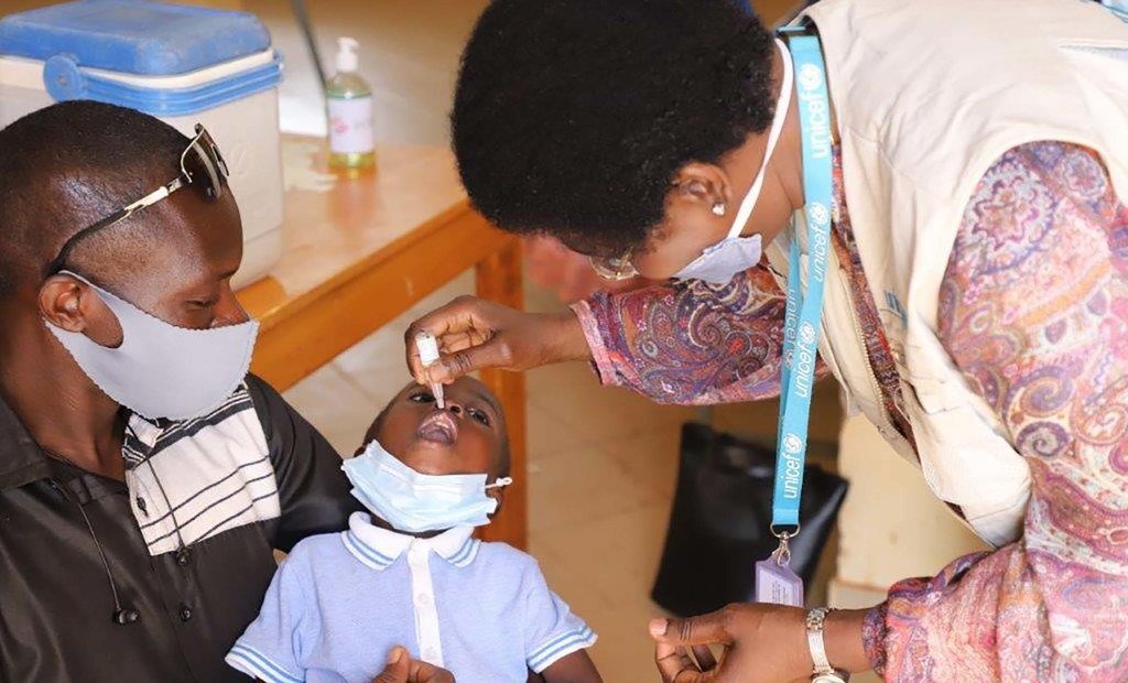 UNICEF staff administering polio vaccine to a child in Burkina Faso