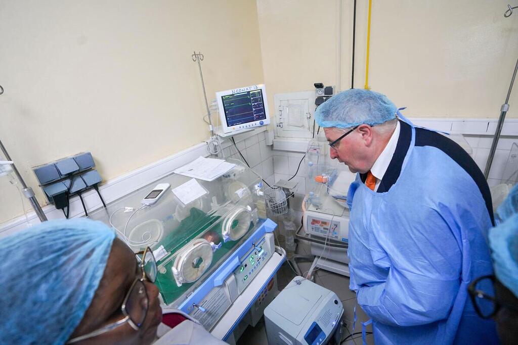 UNFPA Deputy Executive Director Andrew Saberton in medical attire examines an incubator in a Chad hospital maternity ward.