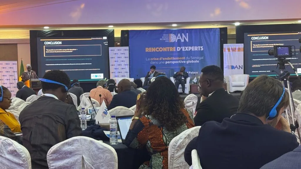 Economists and policymakers in discussion during a conference on Senegal's debt crisis