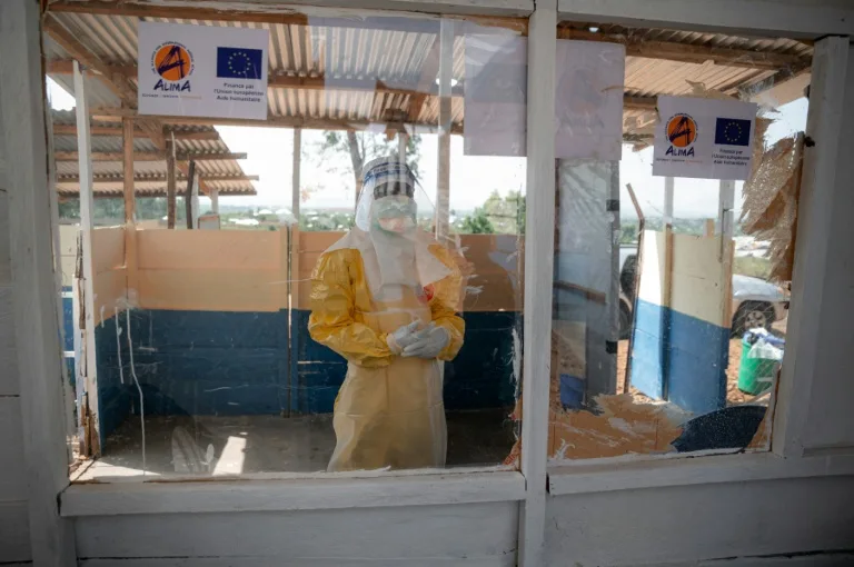 Health worker in protective gear attending to Ebola patient in DR Congo